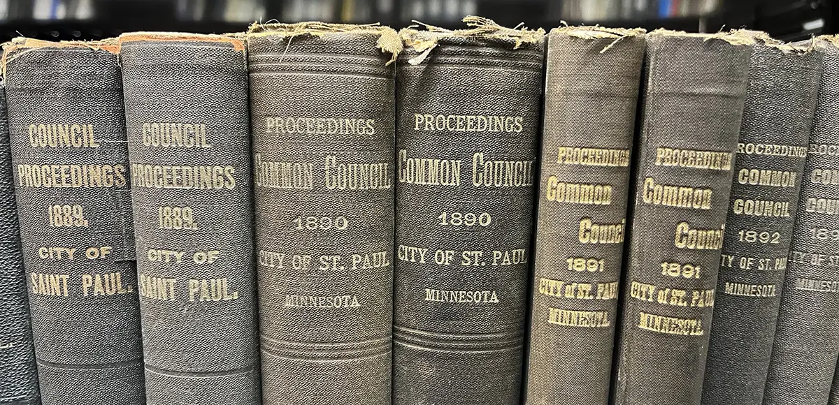 Old city council books lined up on a library shelf